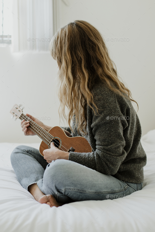 Ti Isse korruption Girl playing ukulele on her bed during quarantine Stock Photo by Rawpixel