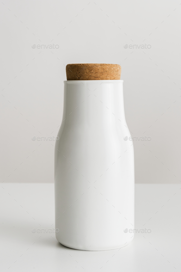 Minimal white metal container sealed with a cork