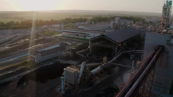Cement Plant with High Factory Structure at Industrial Production Area at Sunset alt