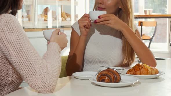 Two Women Having Coffee with Croissants at the Local Bakery Store alt