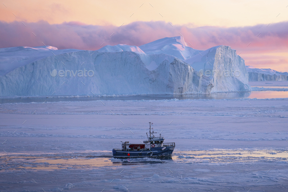 Ice breaker crushing through the frozen sea in the early morning on Greenland