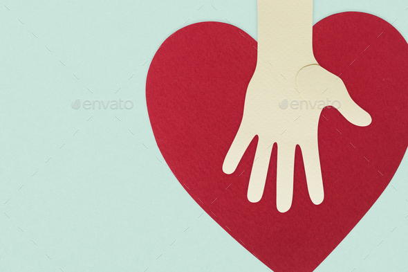 Paper craft hand with a heart supporting donations during coronavirus pandemic background - Stock Photo - Images