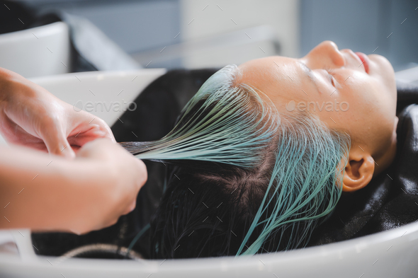 Hairdresser putting mask and coloring on woman's hair in beauty salon - Stock Photo - Images