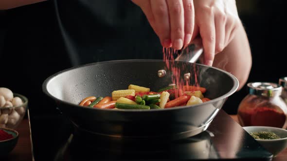 Chef Frying Vegetables in Pan Closeup alt