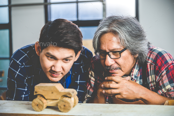 Two adult young Asian Carpenters working and designing the wooden product