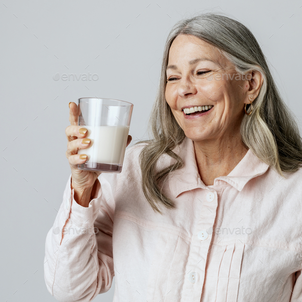 Cheerful senior woman drinking a glass of milk Stock Photo by Rawpixel