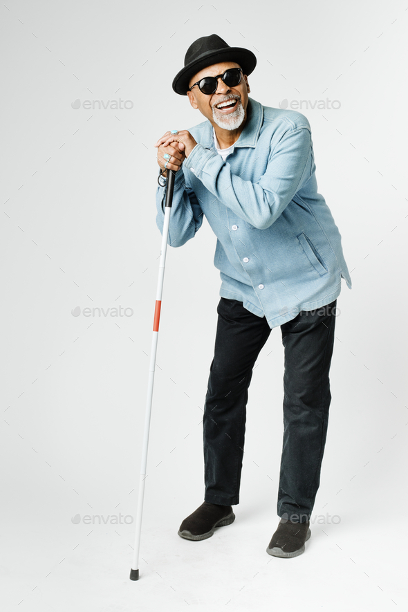 Blind senior man with a cane walking