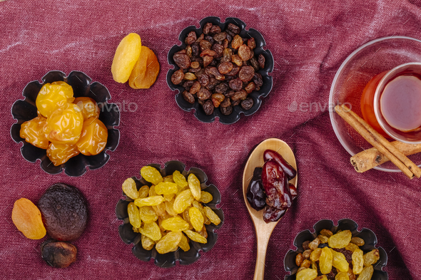 top view of dried fruits cherry plums raisins apricots and dried dates in mini tart tins
