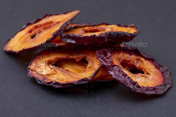 side view of dried plum slices isolated on a black background