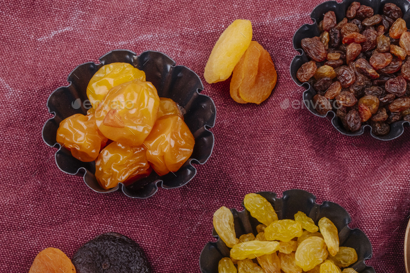 side view of dried fruits cherry plums raisins and apricots in mini tart tins on sackcloth