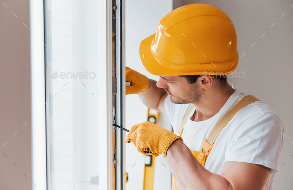 Handyman In Yellow Uniform Installs New Window House Renovation Conception Stock Photo By Mstandret