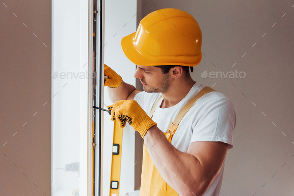 Handyman In Yellow Uniform Installs New Window House Renovation Conception Stock Photo By Mstandret