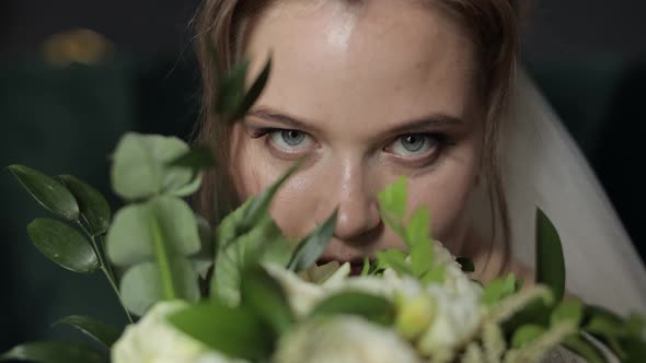 Beautiful, Lovely Bride in Wedding Veil at Home. Wedding Bouquet in Hands From Groom Near Face alt