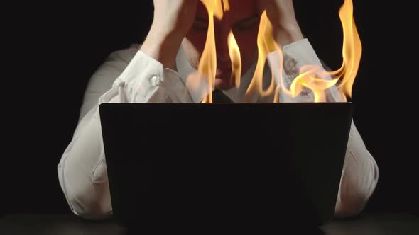Businessman Is Grabbing His Head In Front Of The Burning Laptop