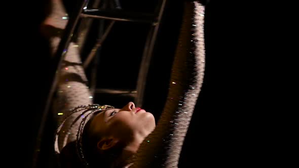 Gymnast a Rotates on a Metal Structure Moon in a Vertical String. Black Background. Slow Motion alt