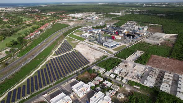 Aerial Flying Over Residencial SeleneV Development Next To CEPM Energy Plant With Rows Of Solar Pane alt
