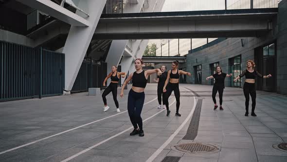Fitness Sport Dance and Lifestyle Concept  Group of Smiling Women with Coach Dancing Outdoors alt