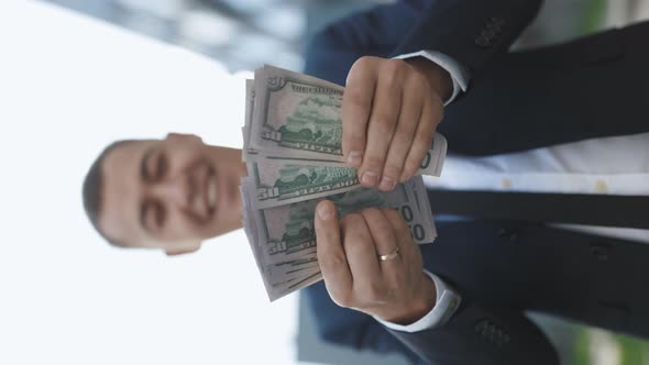 Vertical Video of Young Handsome Rich Man Wearing Stylish Suit Counting Money alt