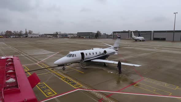 Airport Worker Removing Ice from Wing of Airplane alt