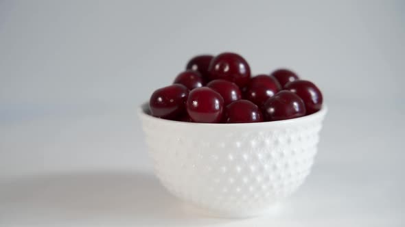 Ripe Large Cherries in a White Plate on a White Background