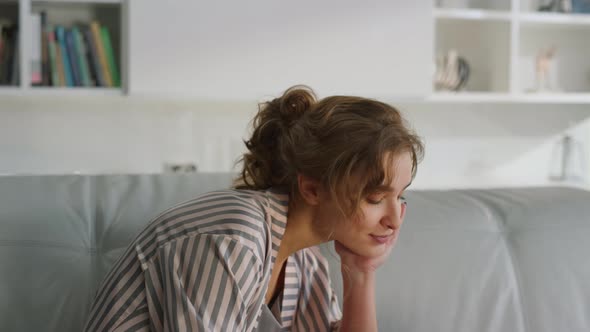 Sleepy Lady Using Laptop in Pajamas Closeup alt