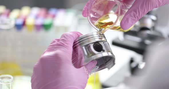 Scientist Chemist Pouring Engine Oil on Piston of Car Closeup  Movie Slow Motion alt