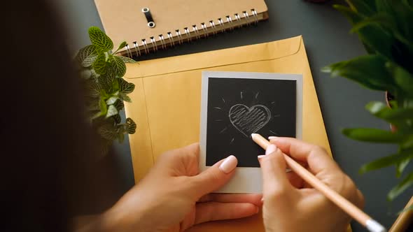 Closeup of the hand of a young girl with a beautiful manicure draw a heart