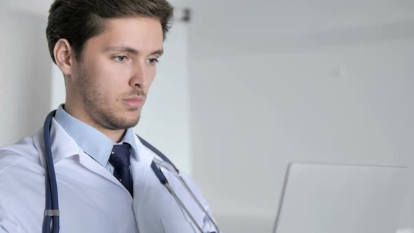 Close Up of Doctor Working On Laptop in Clinic alt