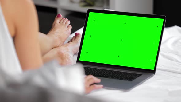 Woman Resting in Bed with Laptop