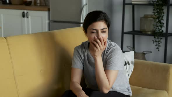 Tired Young Woman Yawns and Lies Down To Rest On The Sofa At Home in The Room alt