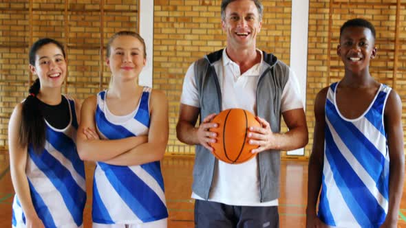 Portrait of coach and schoolkids standing with basketball 4k alt