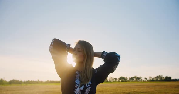 Woman posing and acting on a wheat field at sunset or sunrise alt