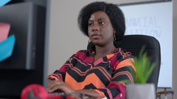 Busy Concentrated African American Freelancer Surfing Internet Sitting at Table and Looking Away alt