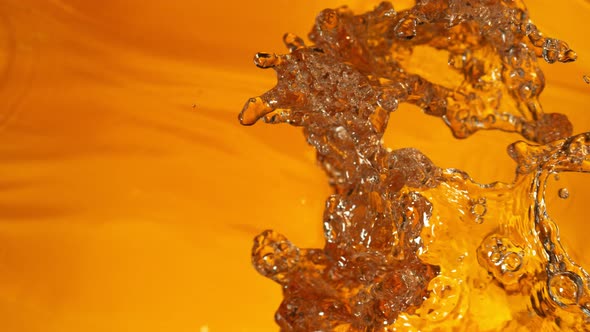 Super Slow Motion Shot of Splashing Golden Liquid at 1000 Fps alt