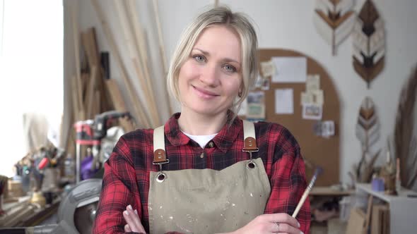 Portrait of a Creative Woman in a Carpentry or Art Workshop alt