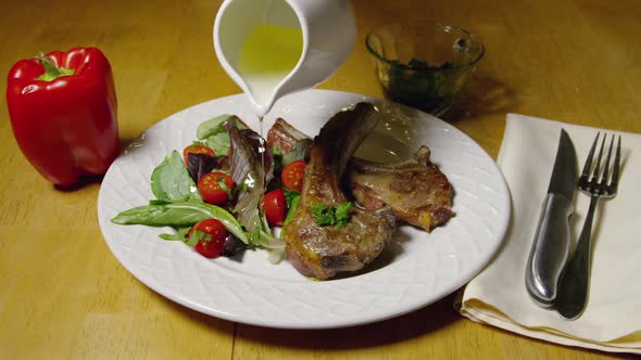 Lamb Chops And Olive Oil Being Poured Over Salad 17