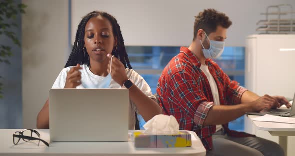 Portrait of Tired African Female Office Worker Remove Safety Mask and Breathe at Workplace alt