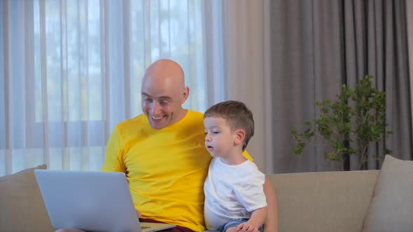 Man Freelancer Working on a Laptop Sitting on a Sofa at Home,businessman Typing on a Laptop,using a alt
