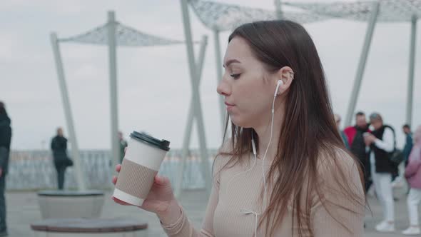 Slow Motion of Happy Young Woman in Headphones Sitting Outdoors in City Having Fun Alone alt