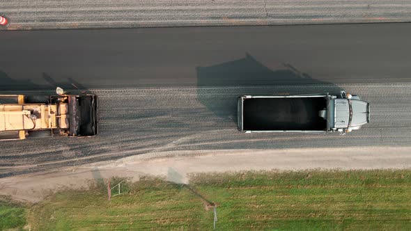 Top down view of road resurfacing crew working on a rural highway on a sunny day.