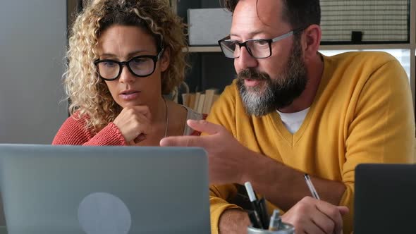 Adult caucasian couple at home in smart working and remote work job activity sitting at the desk alt