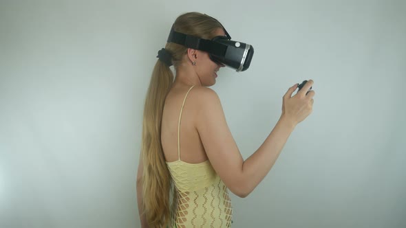 Woman Uses A Virtual Reality Helmet And A Gamepad In A Simulation Game