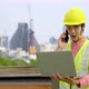 Happy male construction site manager working on laptop and talking on mobile phone while working - VideoHive Item for Sale