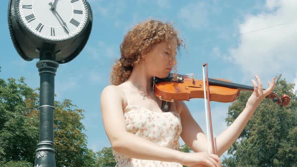 young curly blond woman the violinist: Musician playing violin