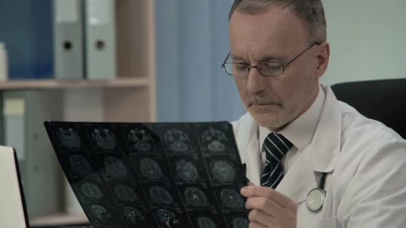 Neurologist Checking MRI Image, Confirms Pathology in Patients Cerebral Cortex alt