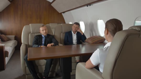 Two Confident Male Entrepreneurs and Successful Female Businesswoman Inside Air Plane alt