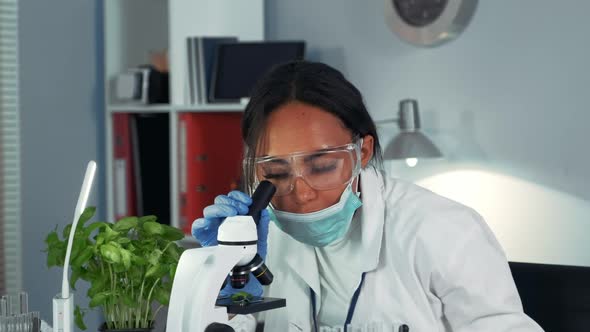 Close-up of Black Female Scientist Getting Amazed with the Result of the Experiment Seen Under the alt