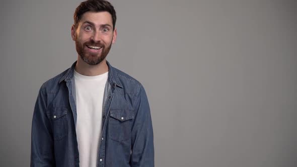 Advertise here. Positive bearded man pointing finger away paying your attention at empty space alt