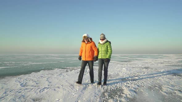 Couple Walking Over Frozen Lake in Winter