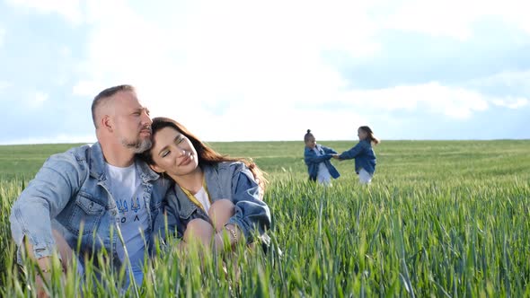Happy Family of Farmers with Son and Daughter Walking on a Wheat Field alt